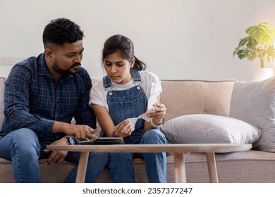 Young couple stressing about bills and invoices in living room Increased expenses cause stress. - Shutterstock ID 2357377247
