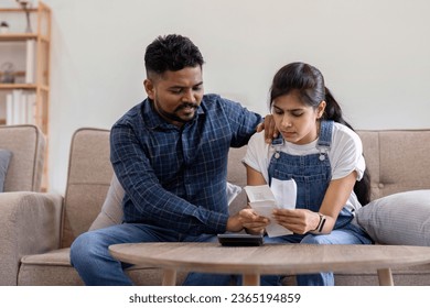 Young couple stressing about bills and invoices in living room Increased expenses cause stress. - Shutterstock ID 2365194859
