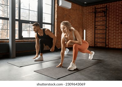 Young couple stretching legs at training gym class - Powered by Shutterstock