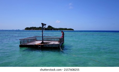 A Young Couple Sunbathing On A Pontoon Boat In The Sea, Rasdhoo Island, The Maldives