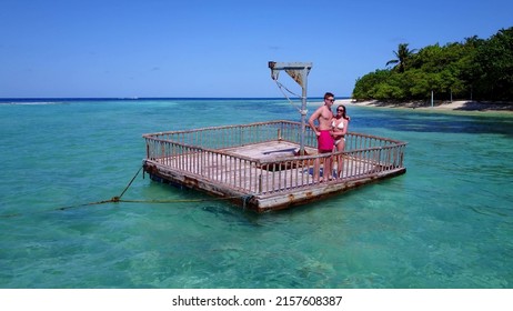 A Young Couple Sunbathing On A Pontoon Boat In The Sea, Rasdhoo Island, The Maldives