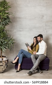 Young Couple With Tablet On Sofa
