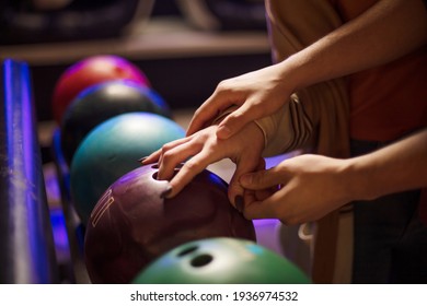 Young Couple Taking Bowling Ball. Close Up. Focus Is On Hands.