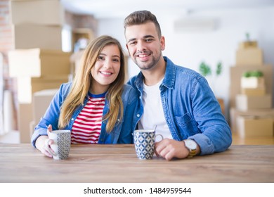 Kleines Paar, das eine Pause macht und eine Tasse Kaffee trinkt, freut sich sehr, in ein neues Zuhause umgezogen zu sein