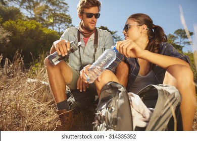 Young Couple Taking A Break On A Hike. Caucasian Man And Woman Drinking Water While Out Hiking