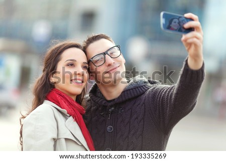 Similar – couple taking selfie in the street