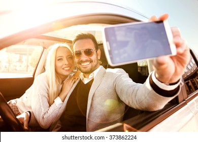 Young Couple Taking A Selfie In Car