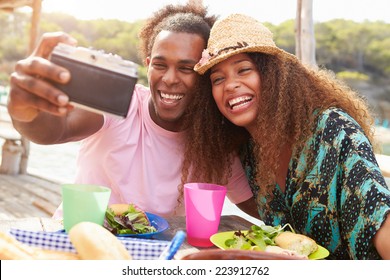 Young Couple Taking Selfie During Lunch Outdoors - Powered by Shutterstock