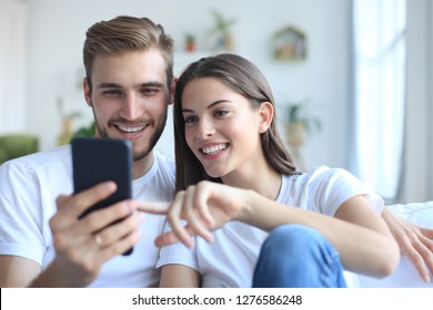 Young Couple Taking A Selfie On Couch At Home In The Living Room.