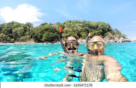 Young Couple Taking Selfie In Tropical Scenario With Waterproof Camera - Boat Trip Snorkeling Excursion At Similan Islands - Youth Lifestyle And Travel Concept Around World - Bright Vivid Filter