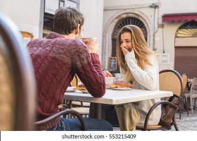 Young Couple Talking at Coffee Shop on a date. Loving couple having fun at a restaurant.