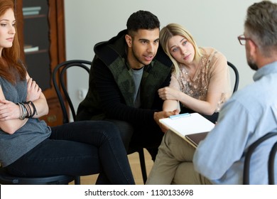 A young couple talking to a psychologist about their problems in a group meeting - Shutterstock ID 1130133698