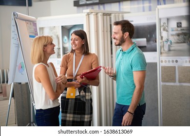 Young Couple Talking With Sales Manager Abut Interior Decor At Ceramic Tiles Store. Choosing, Buying, Selling Concept. Friendly Staff 