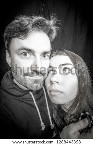 Young couple of teens making funny selfies on fish-eye lens
