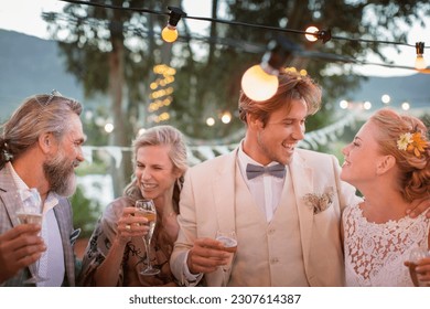 Young couple their guests champagne flutes during wedding reception in garden - Powered by Shutterstock