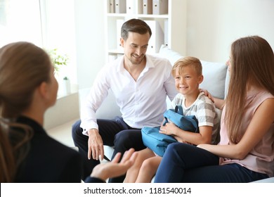 Young Couple And Their Son Meeting With Headmistress At School