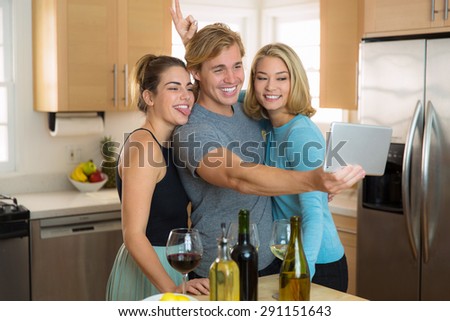 Young couple and third wheel having fun at home pose for a selfie picture to share on their social network