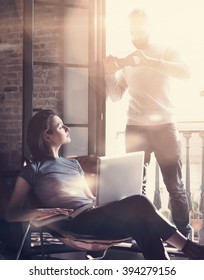 Young Couple Together Vacation. Bearded Man Making Photo Smartphone Beautiful Girl. Working With New Freelance Project In Modern Loft. Using Contemporary Notebook. Vertical, Film Effect. 