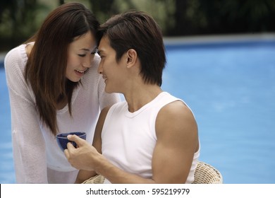 Young Couple Touching Foreheads Poolside