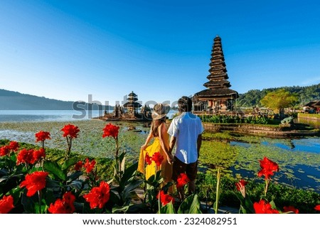 Young couple tourist relaxing and enjoying the beautiful view at Ulun Danu Beratan temple in Bali, Indonesia