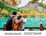 Young couple tourist taking a photo of the beautiful autumn scenery landscape at the Jiuzhaigou national park in Chengdu, China