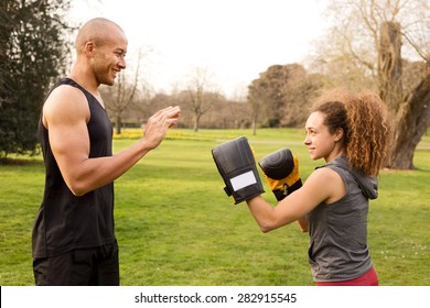 Young Couple Training In The Park Boxing