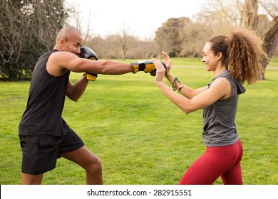 Young Couple Training In The Park Boxing