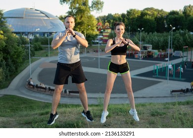 Young couple trains outdoors in a Park in the summer at sunset