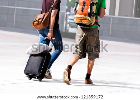 Young couple with a travel bag. Urban scene.