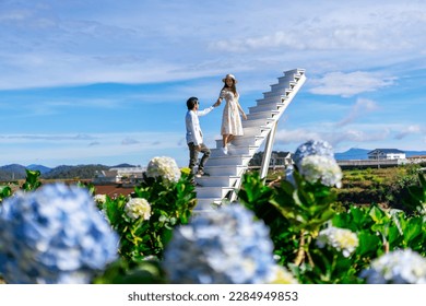 Young couple traveler enjoying with blooming hydrangeas garden in Dalat, Vietnam, Travel lifestyle concept