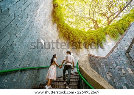 Young couple traveler with giant tree at Fort Canning Tree Tunnel in Singapore