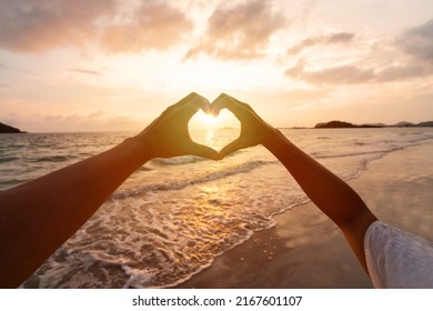 Young couple traveler making heart shape with hands on the beach at sunset, Lovers on honeymoon and Valentine's day concept - Powered by Shutterstock