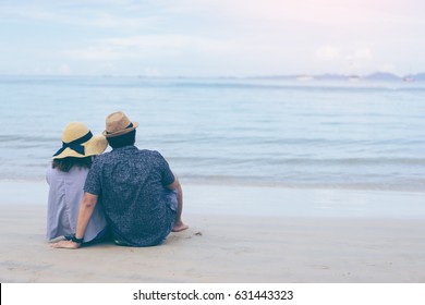 Young couple traveler on a tropical beach at Railay beach Krabi Thailand, Love couple traveler sitting on beach rear view