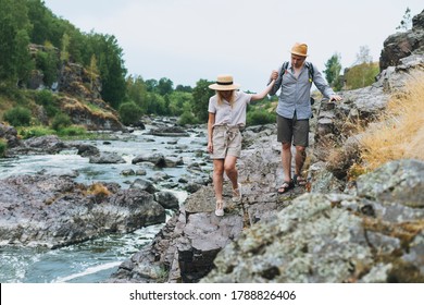 Young Couple Travelers In Casual Outfits Hiking On Mountain River. Local Tourism, Weekend Trip Concept