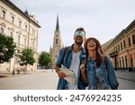 Young couple of travelers laughing and having fun while walking in the city. Copy space.