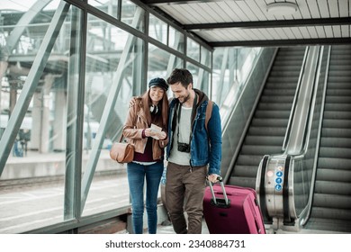 Young couple traveling together and going to their train in a train station