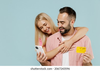 Young Couple Two Friends Family Man Woman In Casual Clothes Using Mobile Cell Phone Credit Bank Card Shopping Online Order Delivery Hug Together Isolated On Pastel Plain Light Blue Background Studio