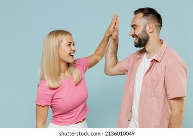 Young couple two friends family man woman in casual clothes meeting together greeting giving high five clapping hands folded together isolated on pastel plain light blue background studio portrait. - Powered by Shutterstock