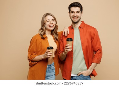 Young couple two friends family man woman wear casual clothes together hold takeaway delivery craft paper brown cup coffee to go isolated on pastel plain light beige color background studio portrait - Powered by Shutterstock