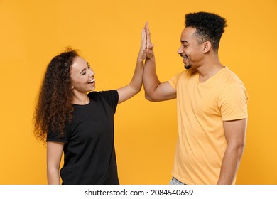 Young Couple Two Friends Together Family Smiling Satisfied African Man Woman In Black T-shirt Meet Together Greeting Giving High Five Clap Hands Folded Isolated On Yellow Background Studio Portrait