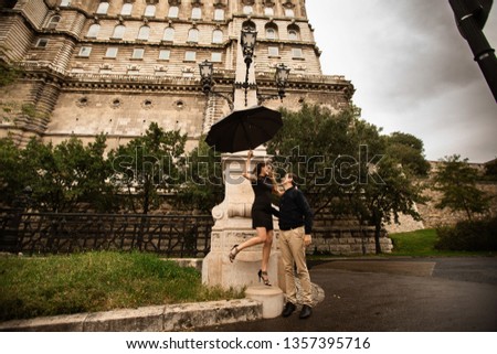 Young couple with umbrella walking in Budapest on a rainy day. Love story
