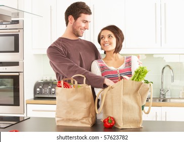 Young Couple Unpacking Shopping In Modern Kitchen - Powered by Shutterstock