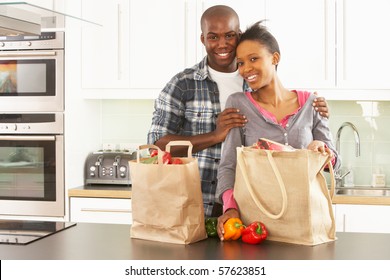 Young Couple Unpacking Shopping In Modern Kitchen - Powered by Shutterstock