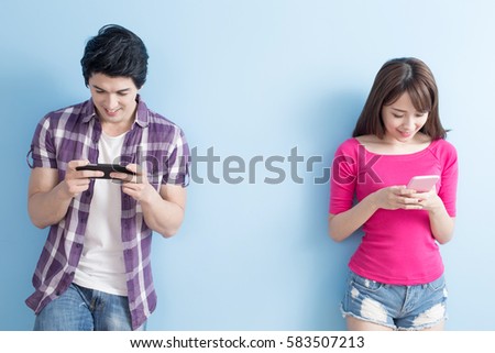 young couple use phone happily with blue background