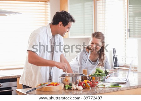 Young couple using the internet to look up recipe