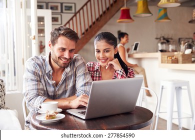 Young Couple Using Laptop In A Cafe