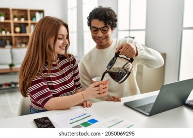 Young couple using laptop and pouring coffee sitting on the table at home. - Powered by Shutterstock