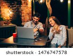young couple using a laptop while relaxing at home together in backyard
