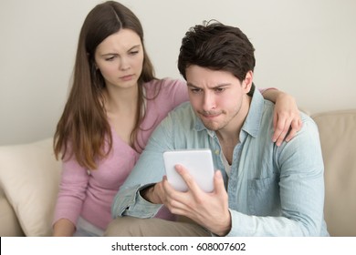 Young couple using tablet, broken, troubles with connection, financial problems, guy playing games, negative and upset, reading bad news, hand on shoulder, mobile banking, insufficient funds