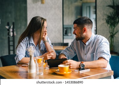 young couple using their tablet during a coffee date - Powered by Shutterstock